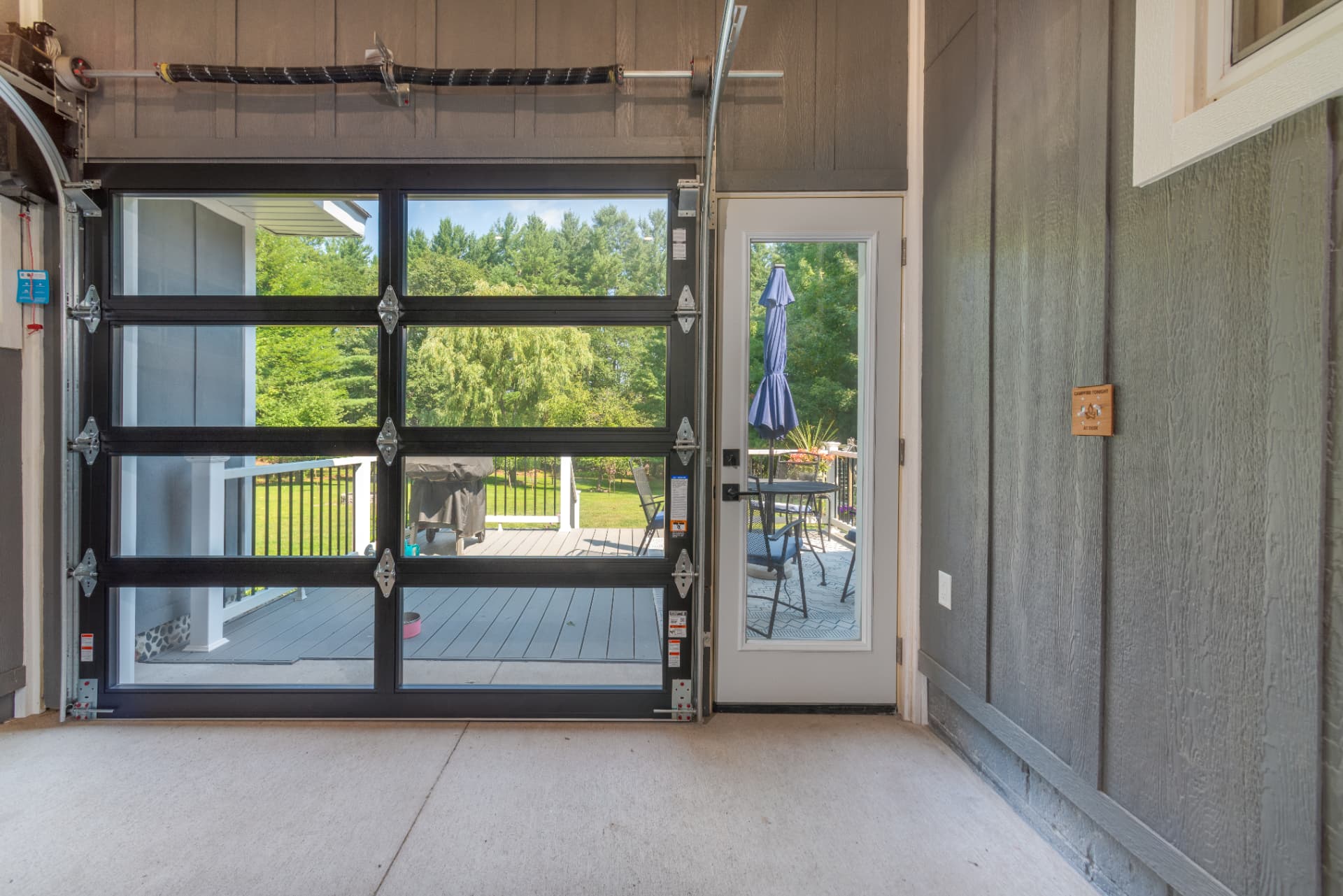 Close up of the black framed glass garage door in the breezeway overlooking a deck in Marquette, MI